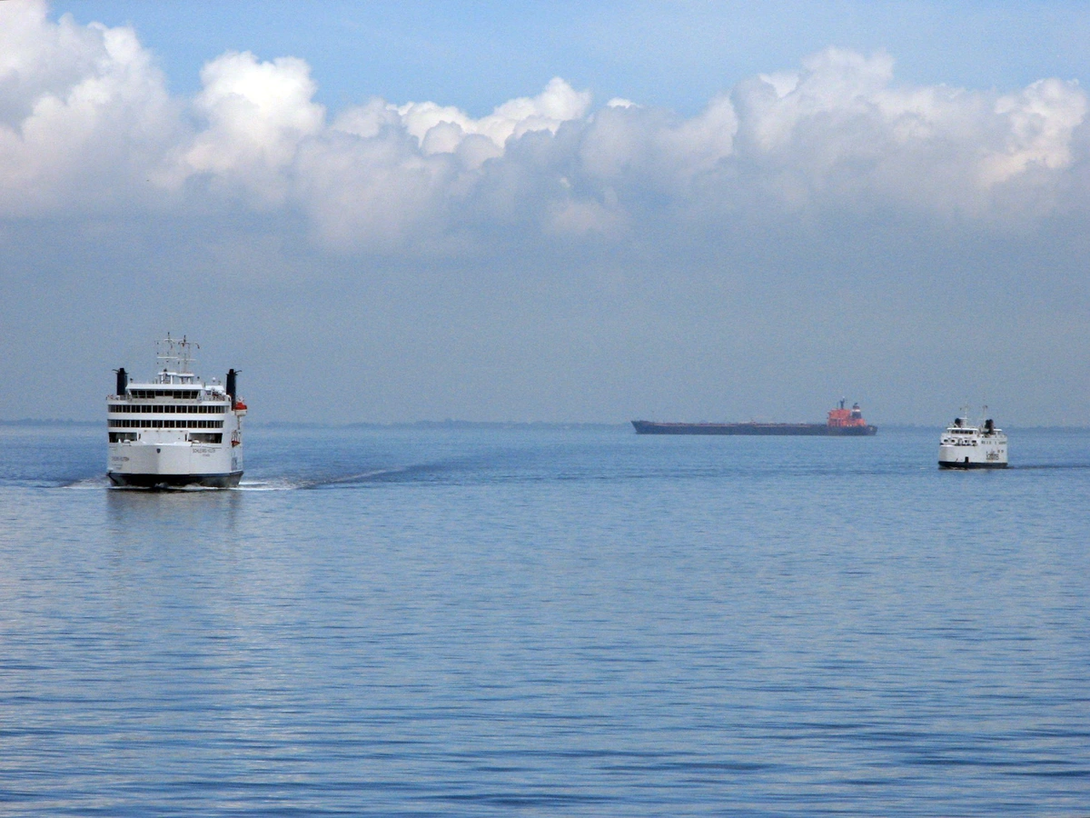Deux ferries sur le Fehmarn Belt ce bras de mer de la Baltique entre l'Allemagne et le Danemark. Un cargo est aussi visible dans le fond. Le ciel est nuageux et la mer calme.

Two ferries on the Fehmarn Belt, a strait of sea on the Baltic sea between Germany and Denmark. A cargo ship is also visible in the background. The sky is cloudy and the sea is quiet. 
